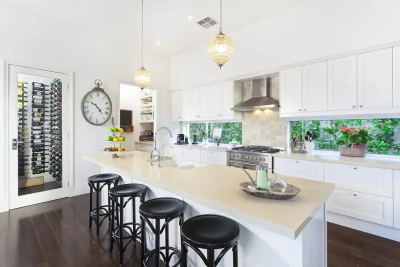 Bright contemporary kitchen with white cabinets and wine pantry