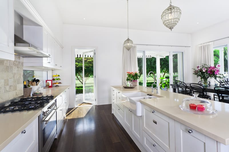 Kitchen with white shaker style cabinets, white quartz counter and dark hardwood floors
