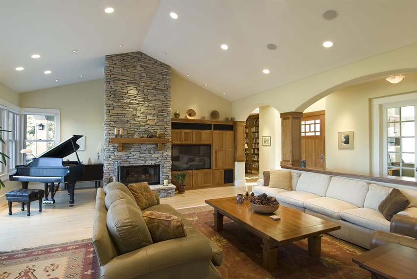 Large living room with stone fireplace and grand piano