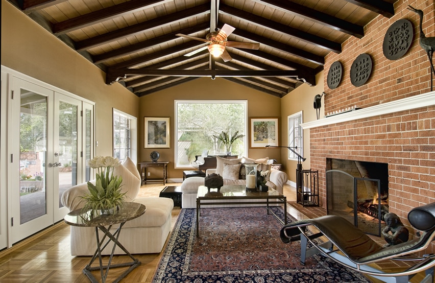 Design with exposed beams and large brick fireplace