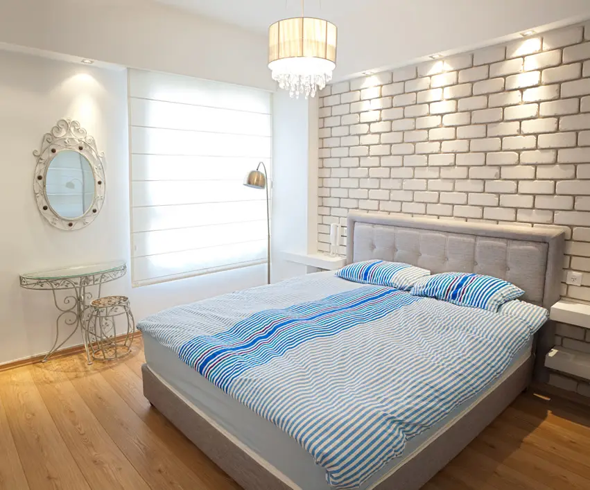 Bedroom with white brick walls, maple floors and cantilevered shelves