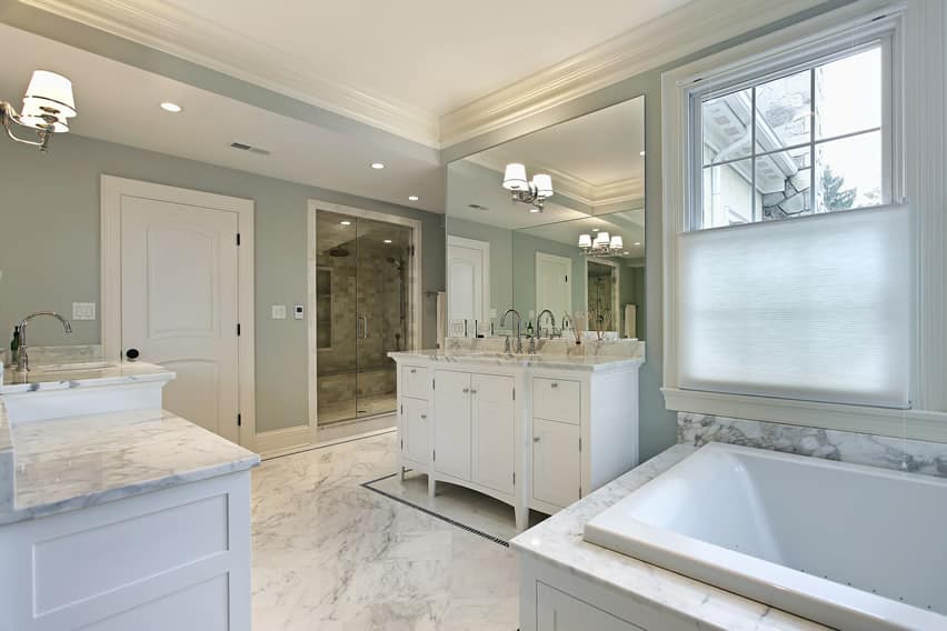 Bathroom with powder blue walls, tall mirror and glass door