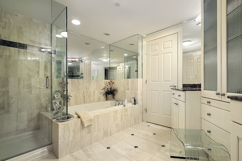 Bathroom in white with large glass shower and mirrored walls