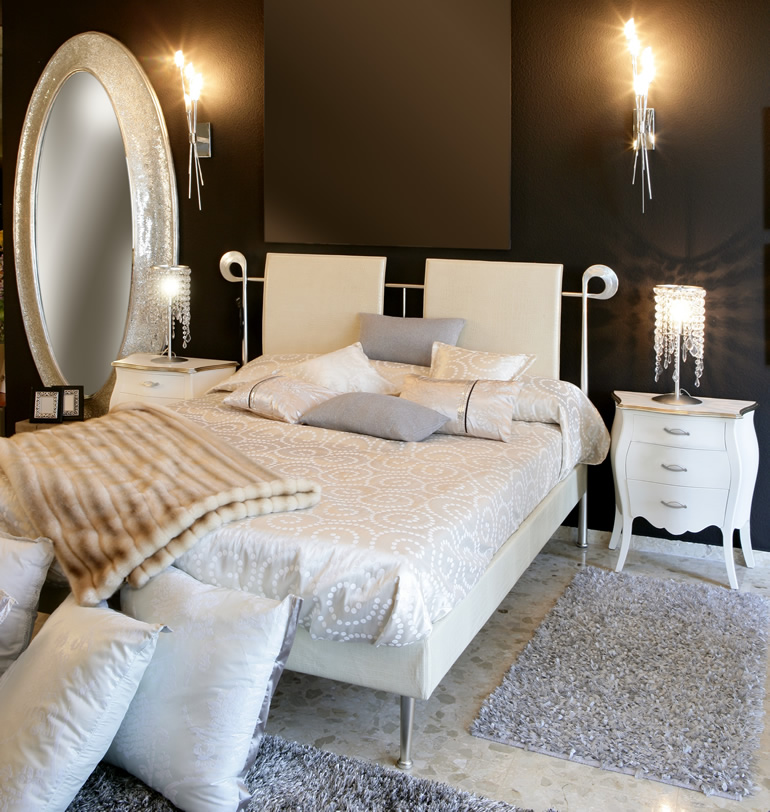 Bedroom with oval mirror, bed and sconce