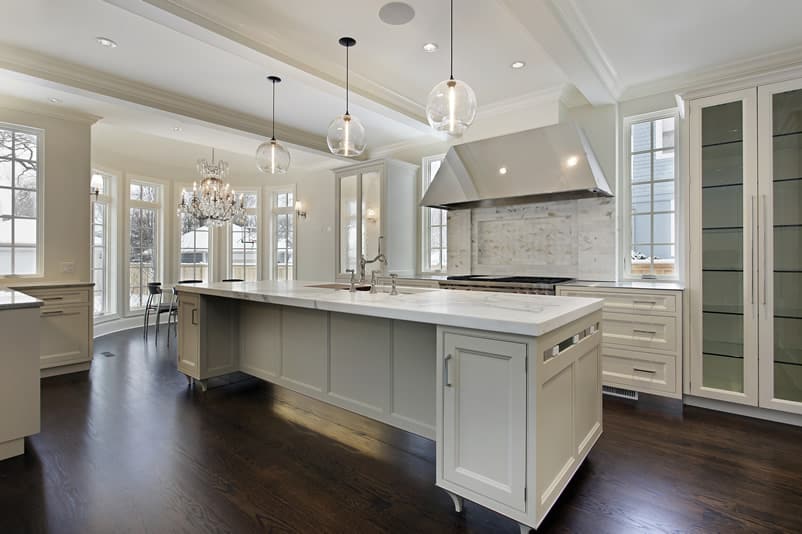 Modern white cabinet kitchen with beautiful light fixtures, pendant lights and dark wood floors