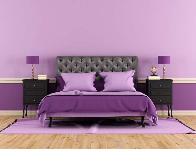 Purple bedroom black headboard hardwood flooring