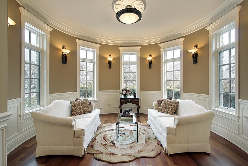 Round formal room with wall sconces and multiple windows