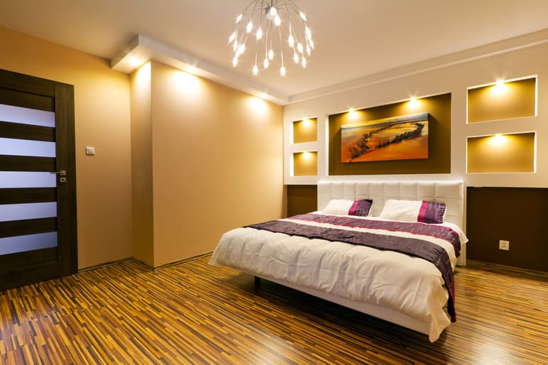 Bedroom with modern lighting, brown wallpaint and door with wood slants