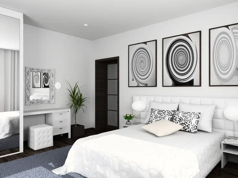 Bedroom with abstract art, white dresser and green plant