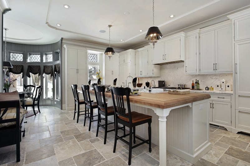 Kitchen with butcher block island abd black chairs