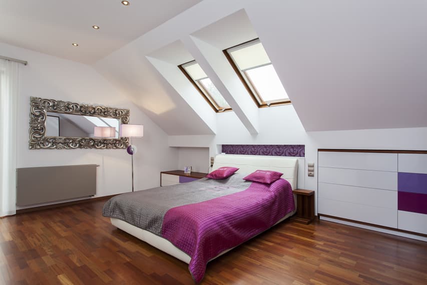 Attic room with sloped wall, silver gilded mirror and small table