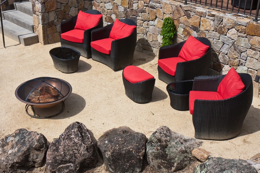 Backyard metal fire pit with comy red black chairs