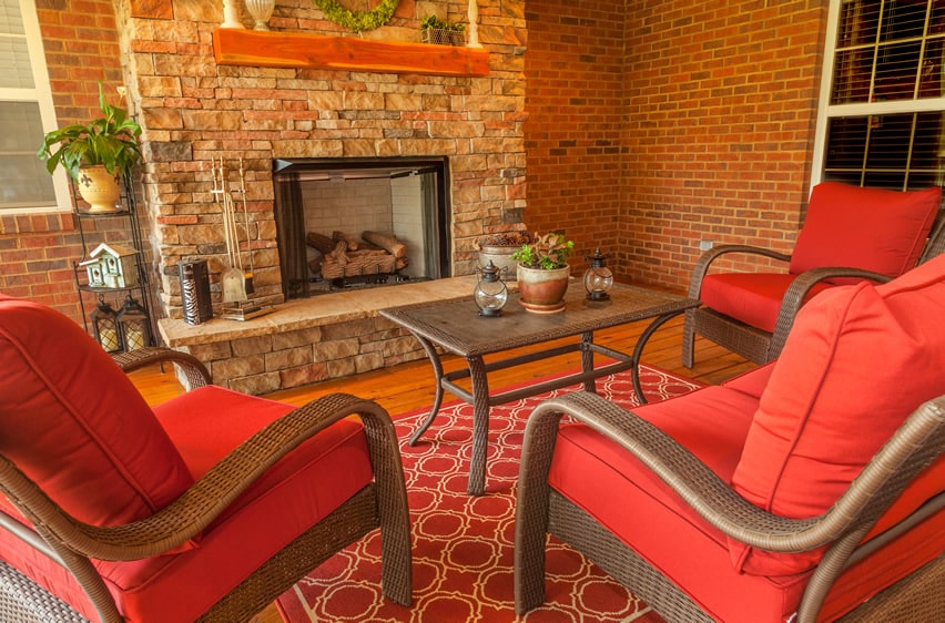 Indoor patio with brick fireplace and comfy furniture