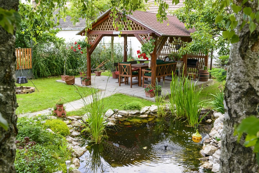 Backyard pond with outdoor dining canopy