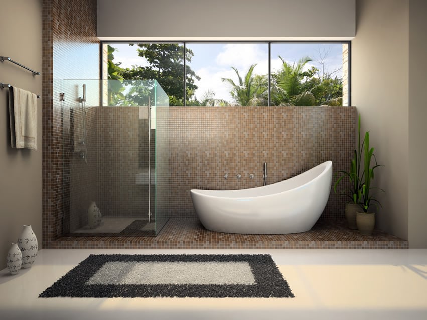 Modern bathroom design with large plain white porcelain tiles and sloped bath tub