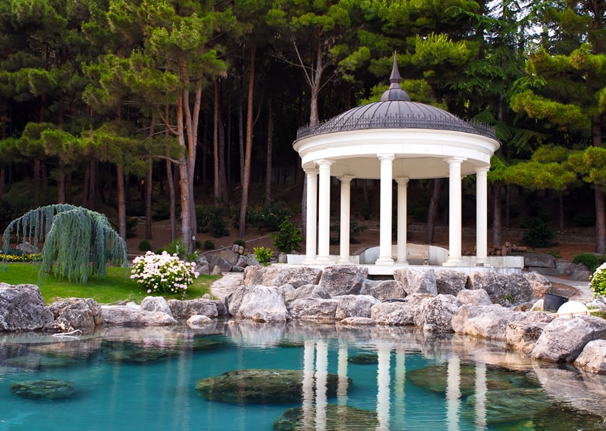 Beautiful gazebo on pond with large rock boulders