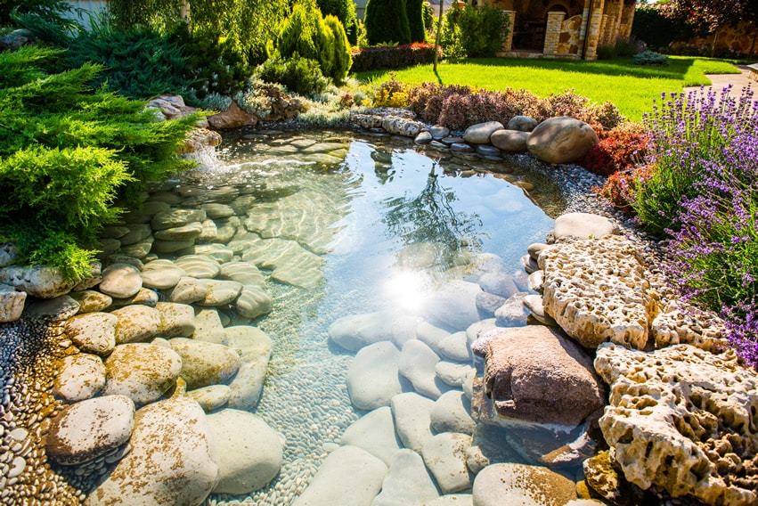 Beautiful water feature pond with natural stones in garden
