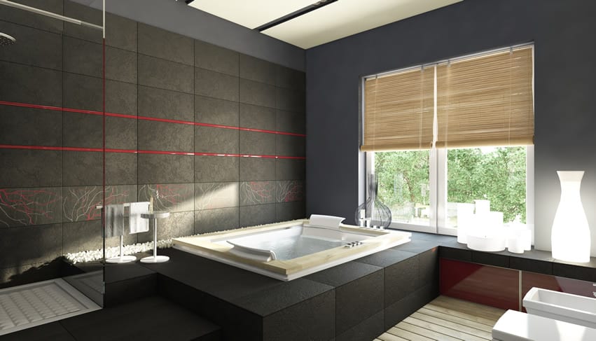 Zen-inspired bathroom with dark brown tiles, alcove tub and bamboo blinds on window