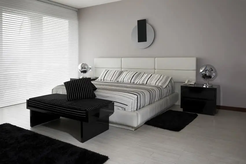 Bedroom with silver deco, white flooring and black shag rugs