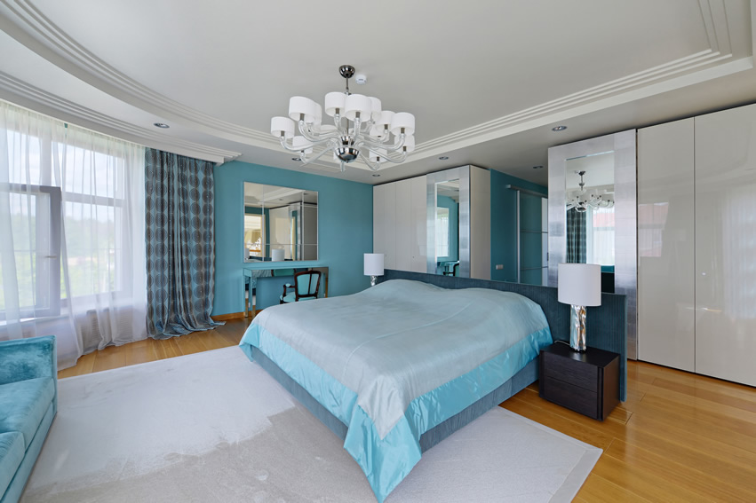 Light acqua blue accent wall, mirrored furniture and white carpet