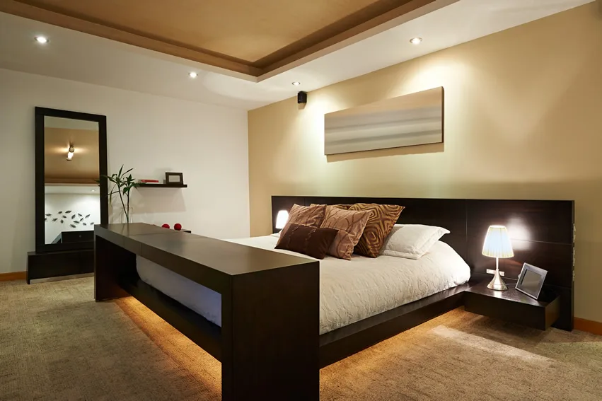 Room with under-bed lighting, wall mirror and vaulted ceiling