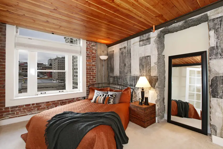 Room with Exposed brick concrete walls and burnt orange bed