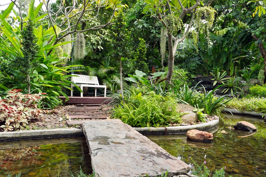 Garden sitting bench with bridge over pond