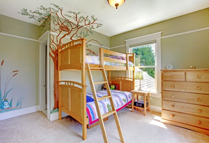 Green themed girl's bedroom with mural of a tree with birds nest