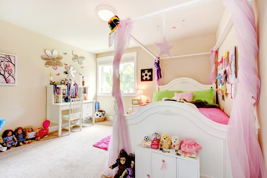 Bedroom with lace canopy curtains and dolls on the floor