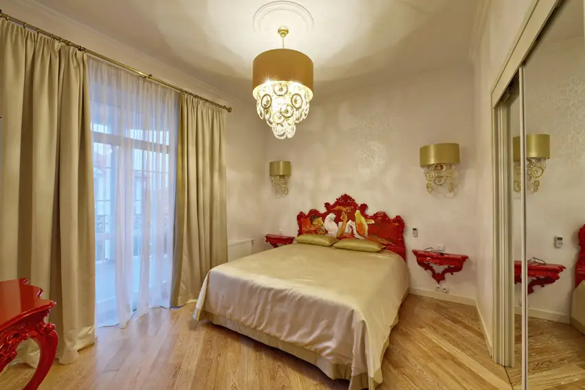Gold and red theme bedroom with hanging lamp and red table