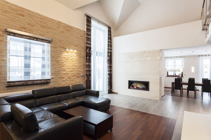 Grand design room with exposed brick and marble fireplace