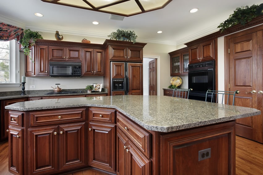 Kitchen with large center granite island and black appliances