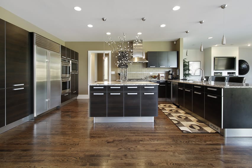 Large luxury kitchen with modern design, dark cabinets and stainless appliances