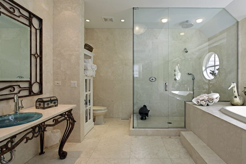 Bathroom with natural non-slip stone tiles in cream and large step in shower