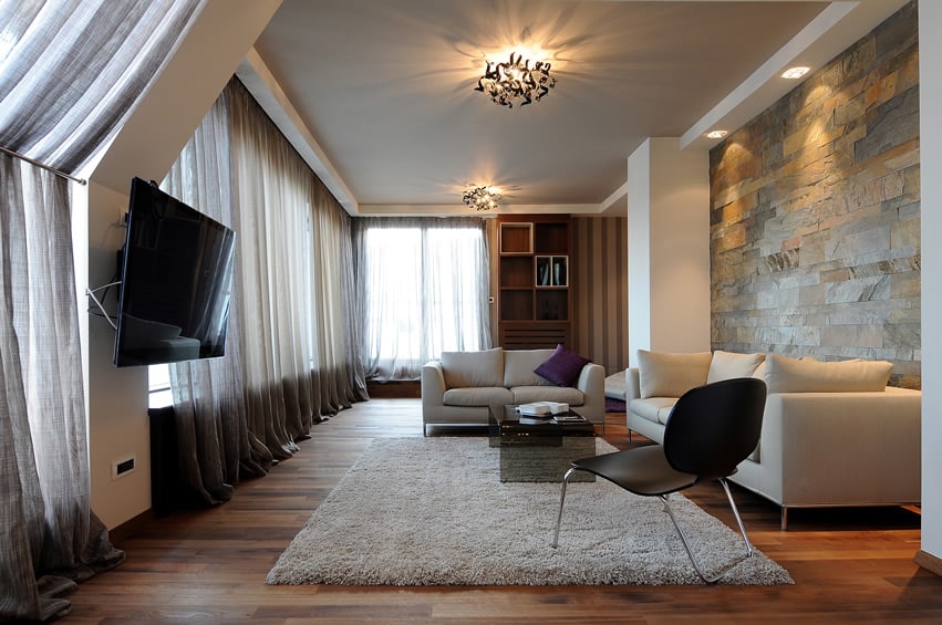 Living room with rock wall and grey ceiling
