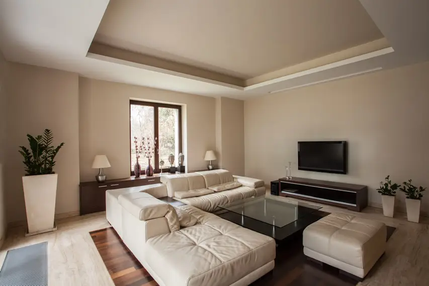 Travertine and hardwood flooring and white sectional couch