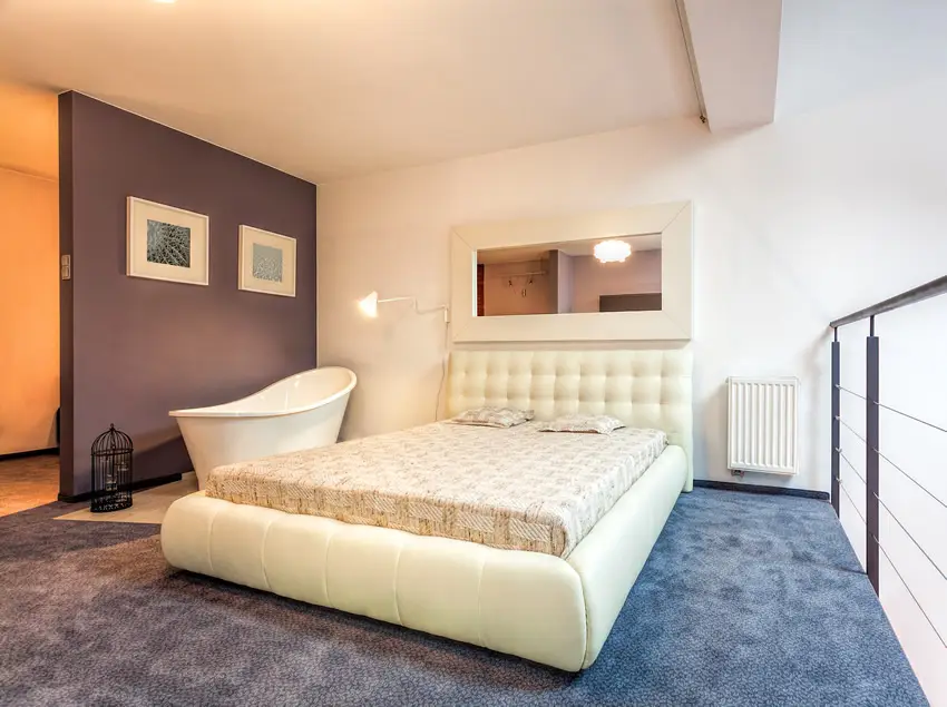 Loft bedroom with bathtub by bed