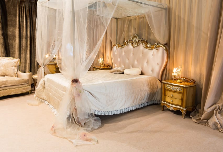 Luxury bedroom with sheer four poster canopy bed gold decor