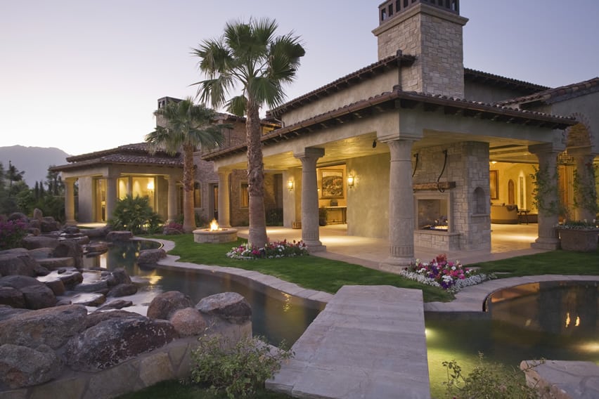 Pond feature with wooden moat, palm trees and decorative rocks