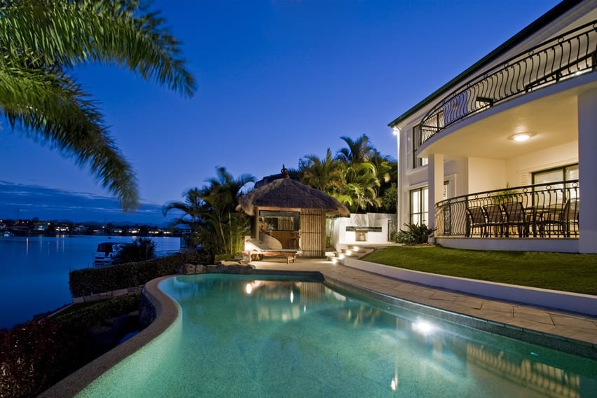Luxury home pool with ocean view at night