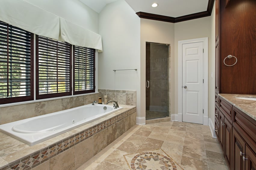 Window with wood blinds, decorative tiles on the floor and dark brown cornices