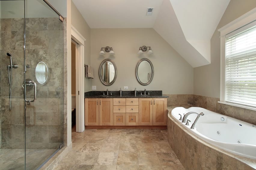 Bthroom with two silver mirrors, pine cabinets amd shower