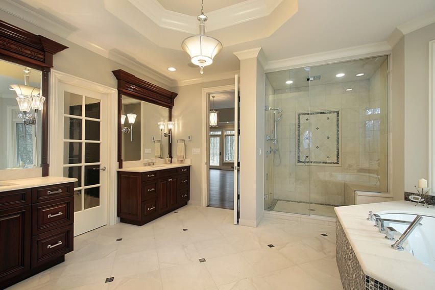 Bath with ceramic floor tiles, white door and mahogany vanities