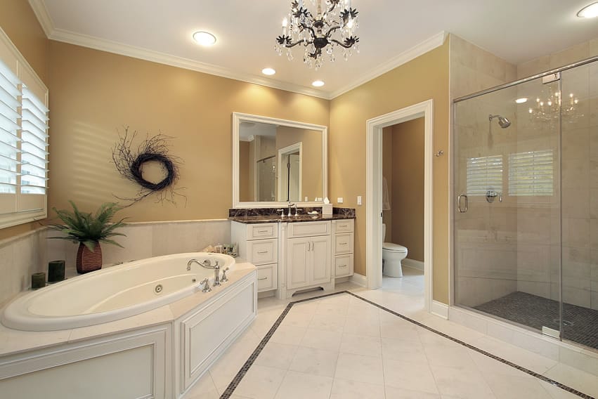 White ceramic tile bathroom with dark gray stone mosaic tiles and beautiful glass chandelier