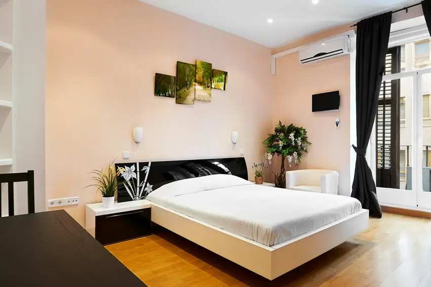 Room with peach walls and black furniture with laminated surfaces