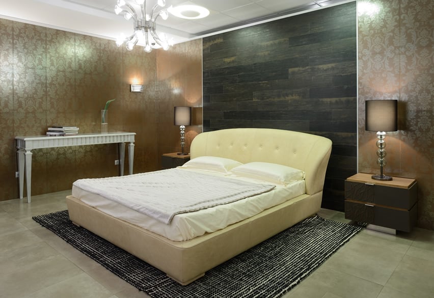 Room with white sleigh bed, concrete-like ceramic tiles and table