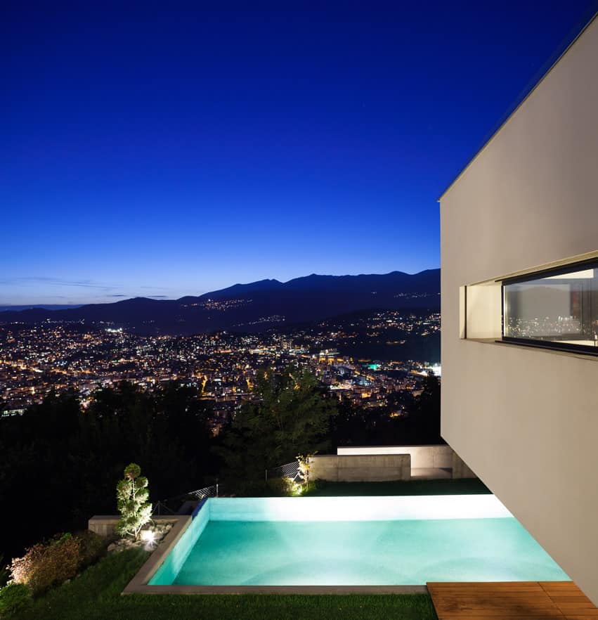 Modern house with pool and city view at night