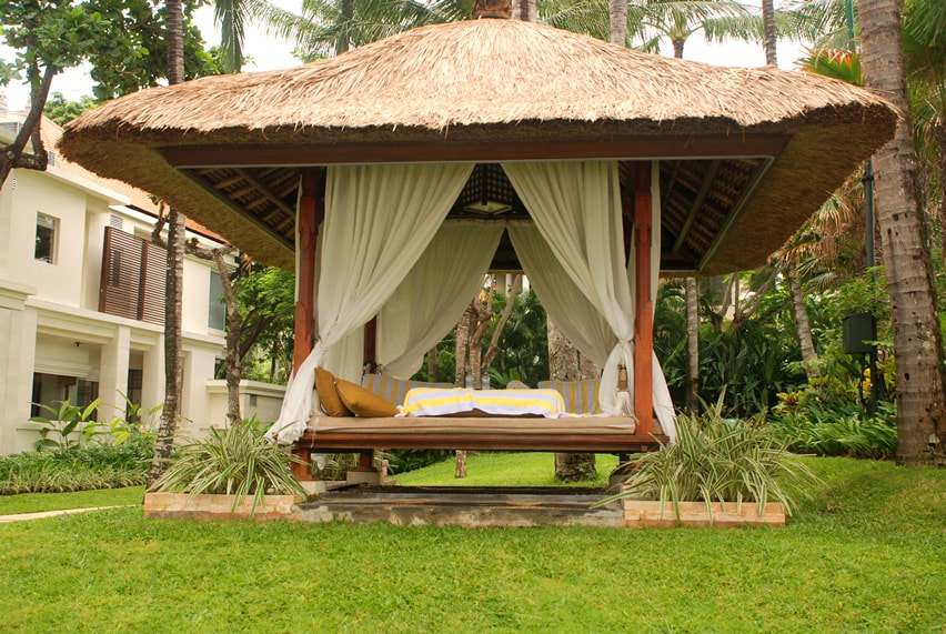 Thatched resort gazebo with curtains and cushions