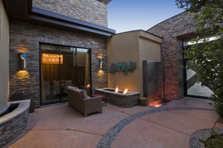 Luxury home open patio area with masonry tiled fireplace