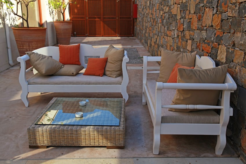 Courtyard patio with stone wall and cushioned outdoor furniture